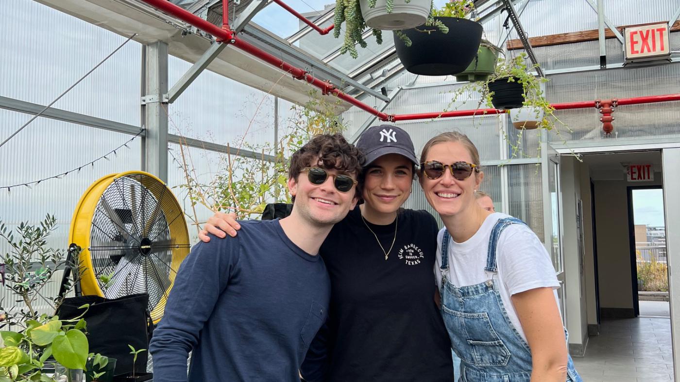 residents in greenhouse with hanging plants
