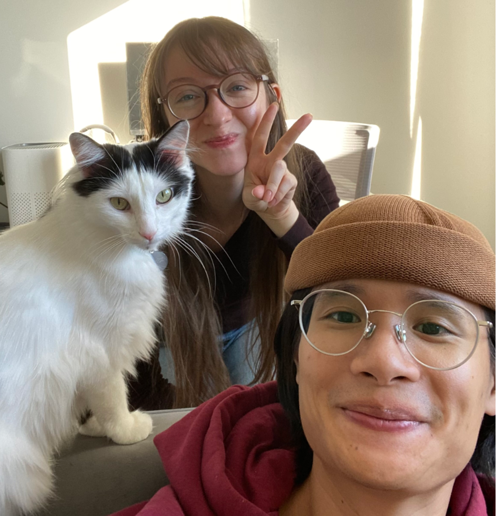 Michaela Dwyer holds up a peace sign and poses with her cat 