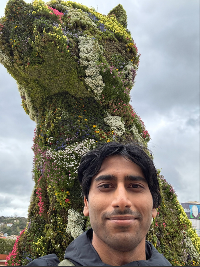 Ved Tanavde poses in front of large topiary dog